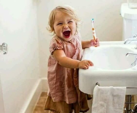 young girl brushing her teeth
